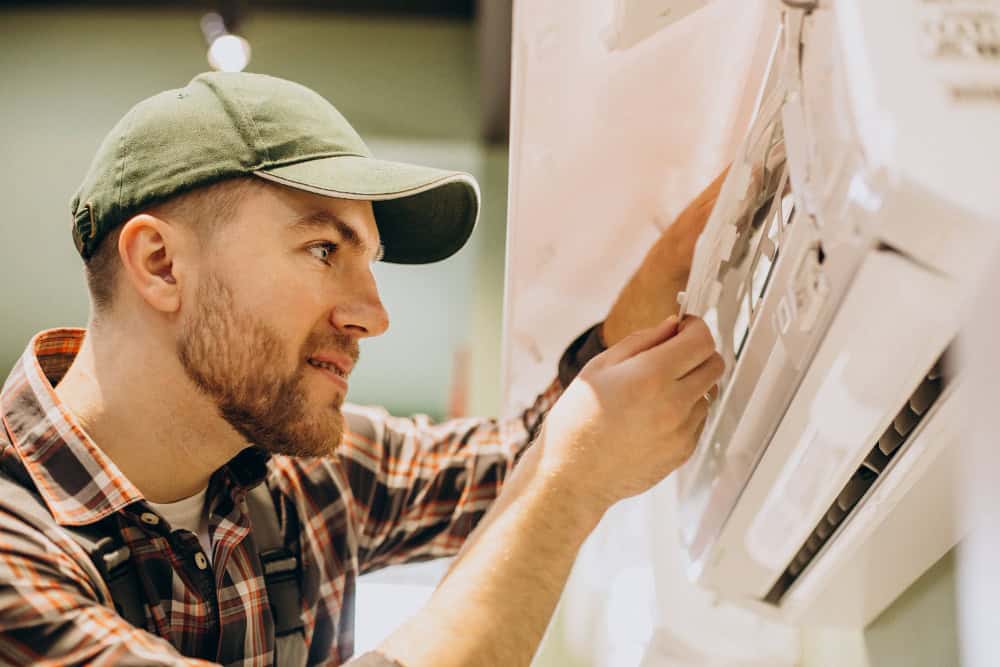 HVAC technician servicing a wall-mounted ductless mini split indoor unit